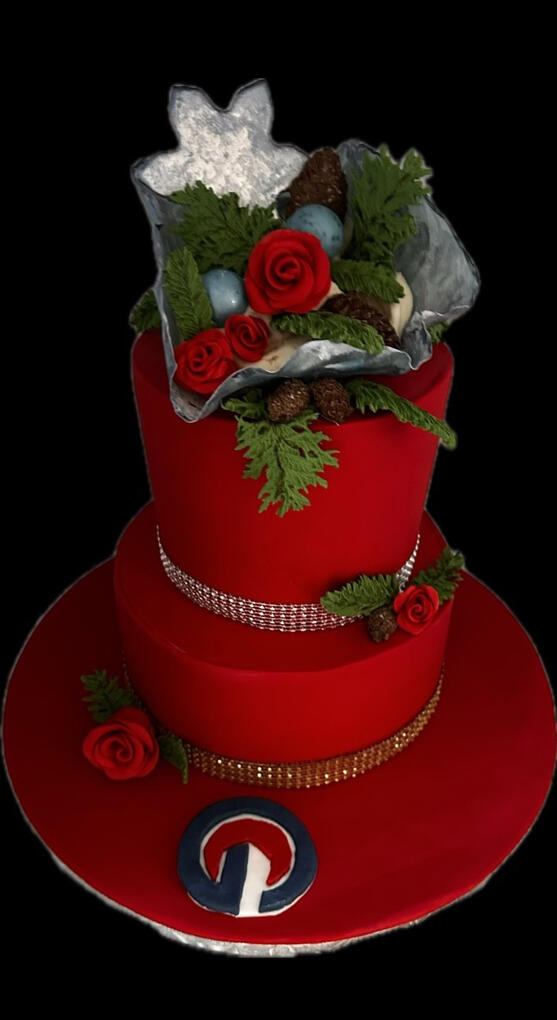 Red corporate Christmas cake decorated with handcrafted roses, greenery, and elegant holiday details.