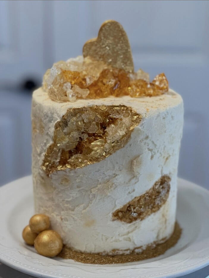 White and gold buttercream cake with sparkling edible geode and gold details.